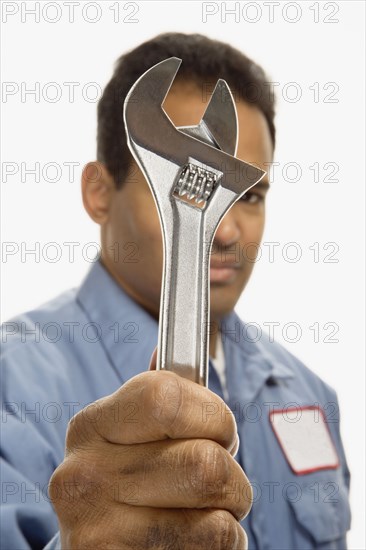 Studio shot of maintenance man holding wrench