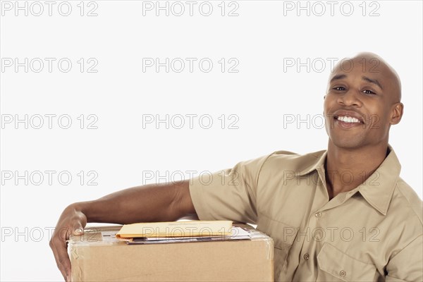 Studio shot of African delivery man with package