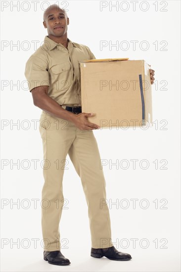 Studio shot of African delivery man with package