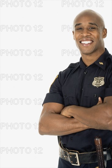 Studio shot of African male police officer smiling