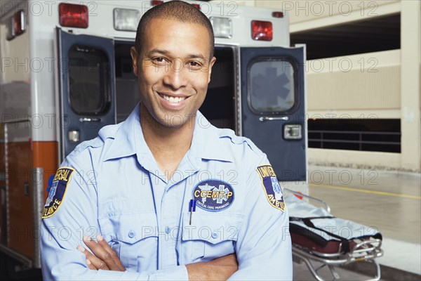 Portrait of African male paramedic in front of ambulance