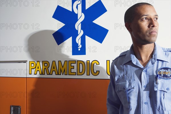 African male paramedic next to ambulance