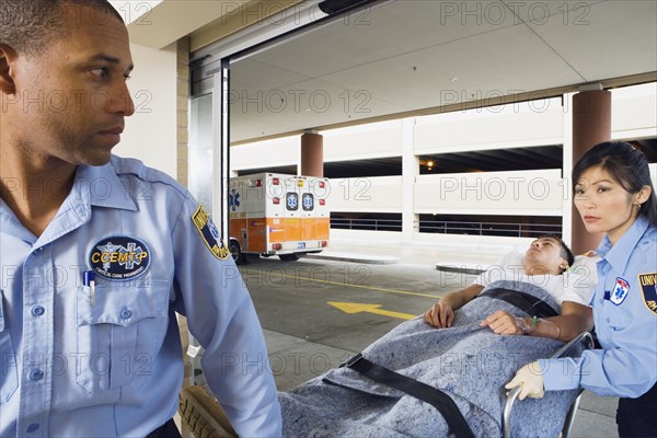 Paramedics wheeling man on gurney