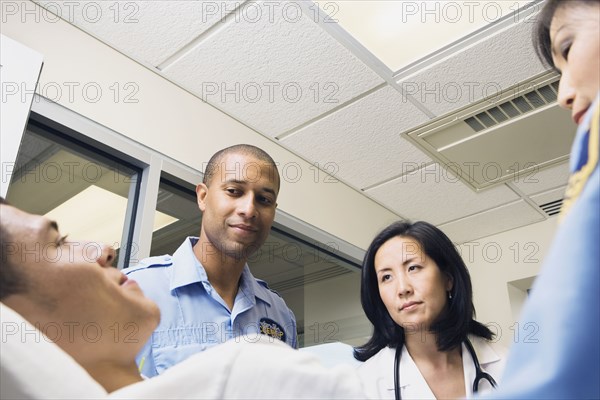 Doctor and paramedics looking at patient