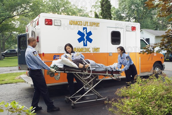 Paramedics putting woman into ambulance