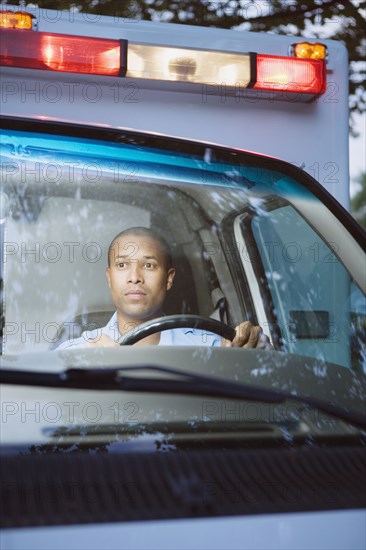 African male paramedic driving ambulance