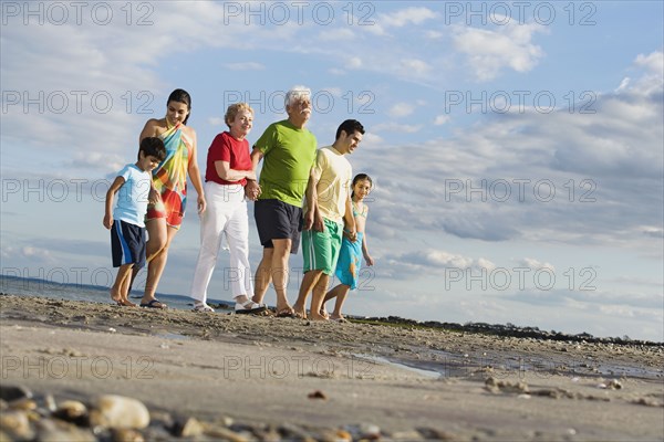 Surface shot of Hispanic family walking on beach