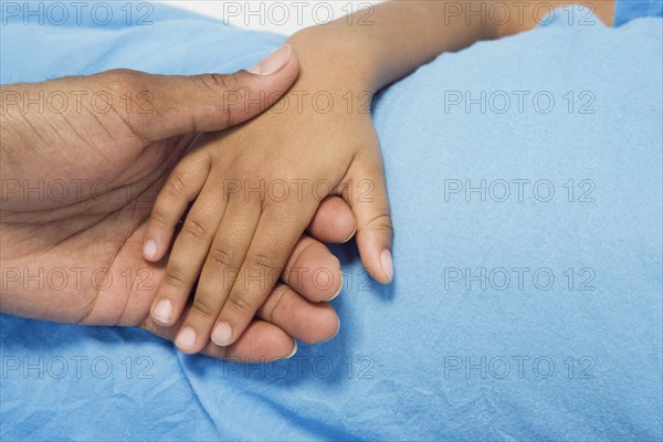 Close up of African boy holding parent's hand