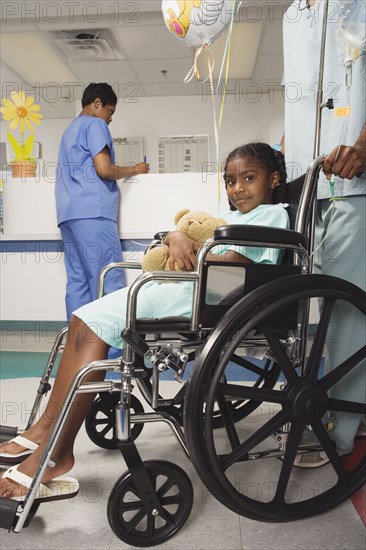 African girl being pushed in wheelchair in hospital