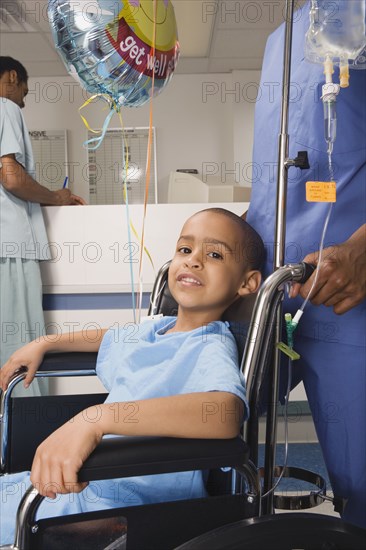 African boy being pushed in wheelchair in hospital