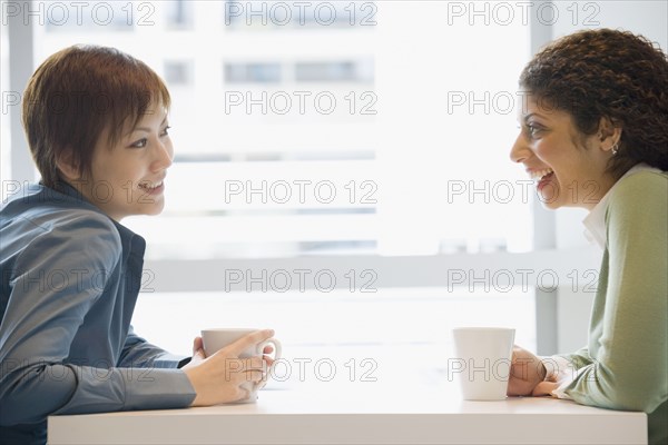 Multi-ethnic women talking at cafe