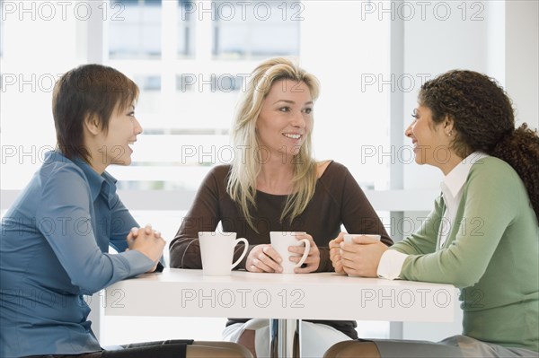 Multi-ethnic women talking at cafe