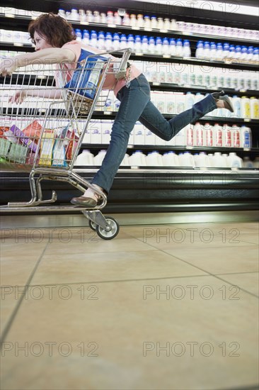 Woman riding on shopping cart