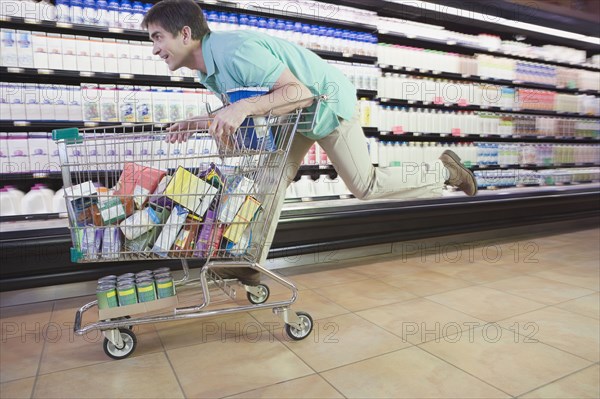 Man riding on shopping cart