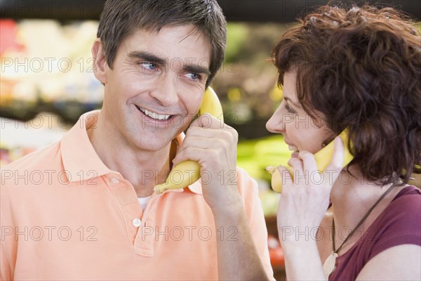 Couple playing with bananas at grocery store