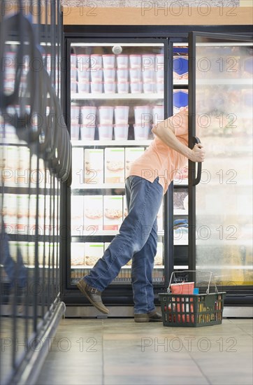 Man looking in freezer at grocery store