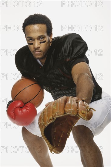 African American man with a variety of sports equipment