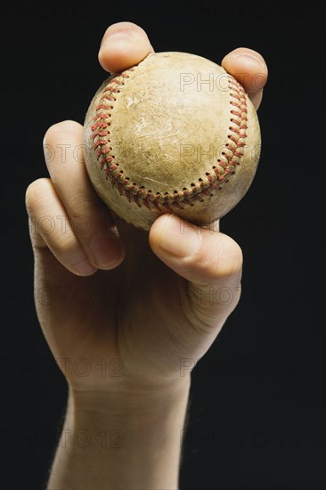 Asian man holding baseball