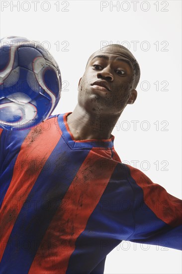 African American male soccer player looking at ball