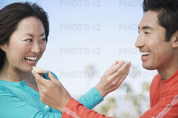 Asian couple feeding each other