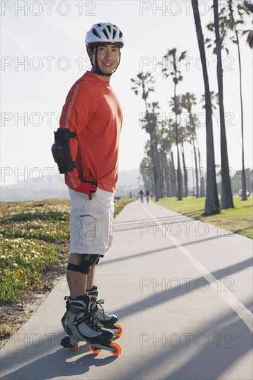 Asian man on rollerblades