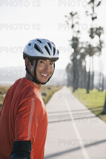 Asian man wearing bicycle helmet