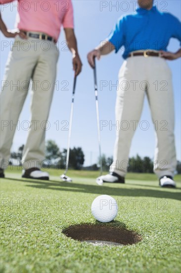 Golf ball next to hole