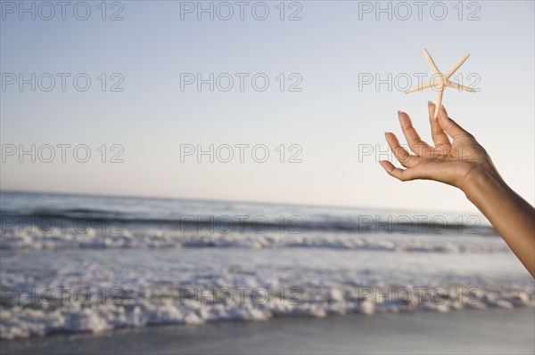 Mixed Race woman holding starfish