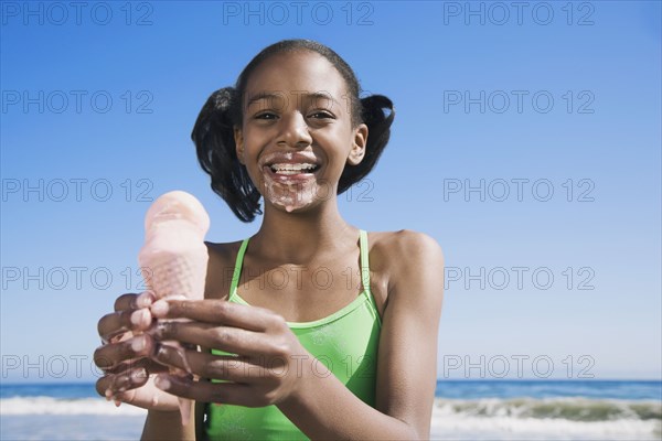 African girl holding melting ice cream cone