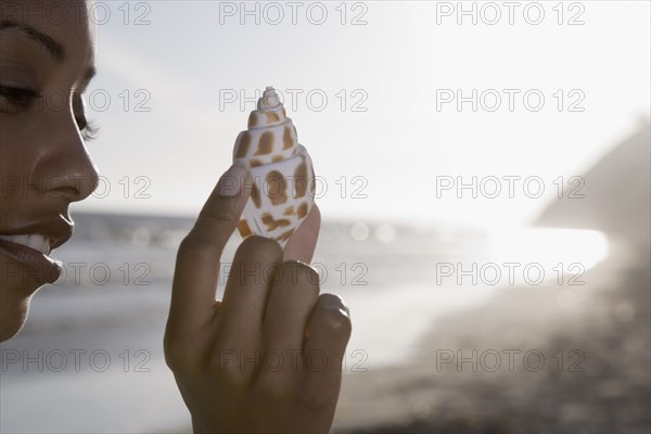 African woman holding seashell