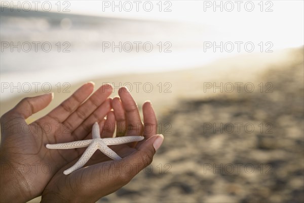 African woman holding starfish