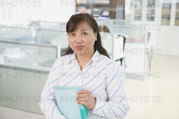 Chinese businesswoman holding binder