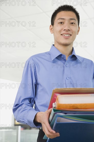 Chinese businessman holding binders