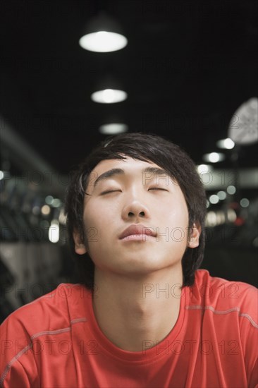 Chinese man with eyes closed in health club