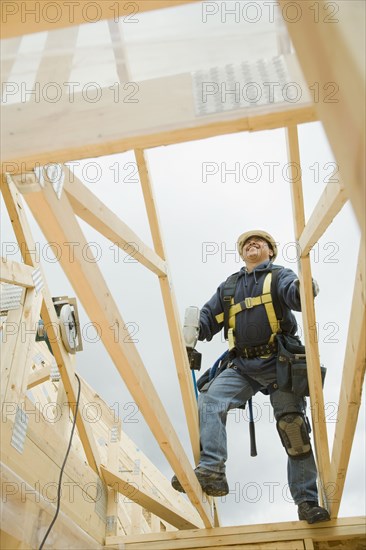 Hispanic construction worker building house