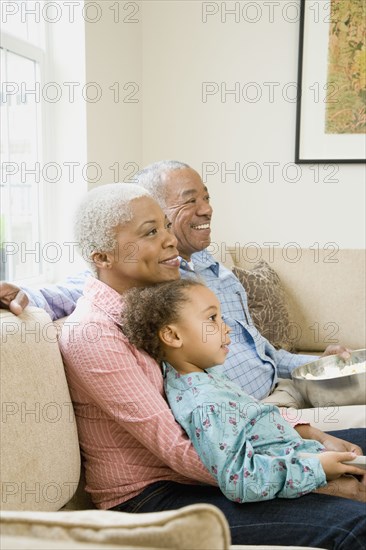 African grandparents with granddaughter in living room