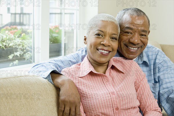 African couple hugging in living room