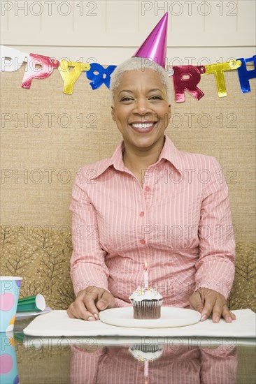 African woman with cupcake at birthday party