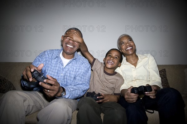 African grandparents playing video game with grandson