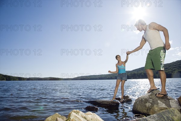 Father and daughter standing by lake