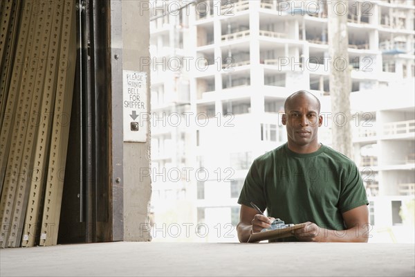 Black man standing near warehouse loading dock