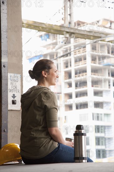 Mixed race woman taking a break on warehouse loading dock