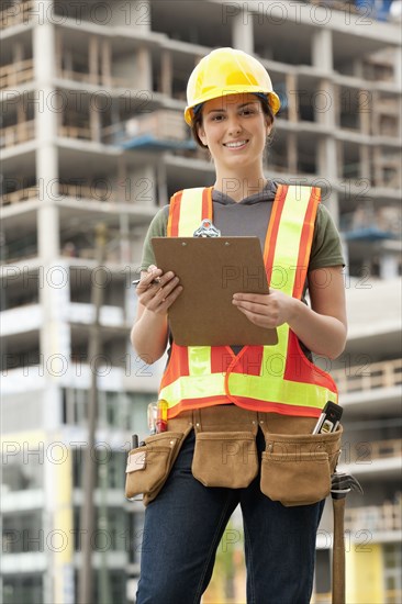 Mixed race woman in hard-hat on construction site