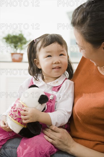 Chinese mother holding daughter on lap