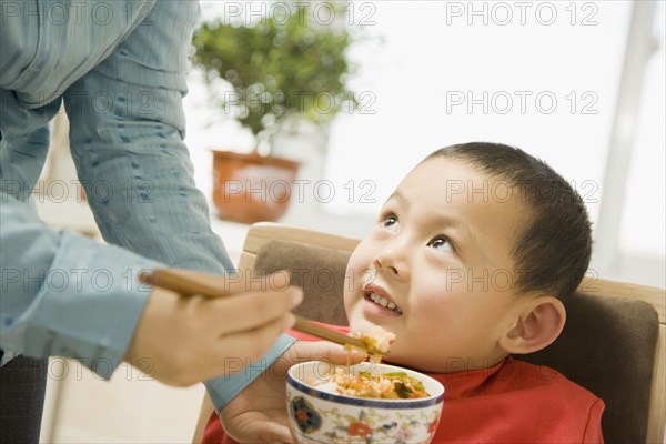 Chinese grandmother feeding son