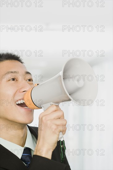 Chinese businessman talking into bullhorn