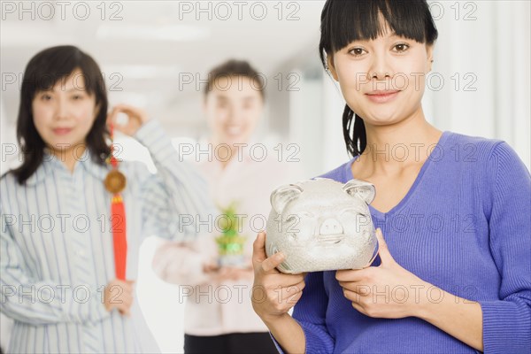 Chinese woman holding piggy bank