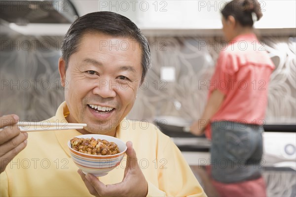 Chinese man eating with chopsticks