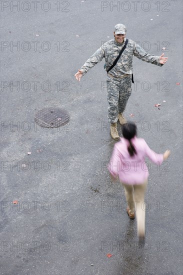 Woman running to soldier with arms outstretched