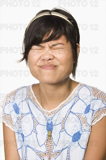 Asian woman scrunching face